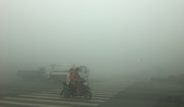 Motorcyclists ride through thick smog on January 9, 2017, in Zhengzhou, China.